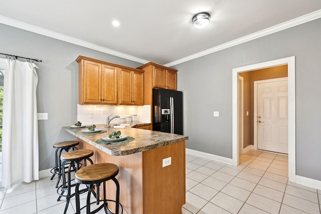 5239 Starnes Dr, Murfreesboro, TN 37128 - kitchen featuring black fridge, a sink, ornamental molding, a kitchen bar, and tasteful backsplash