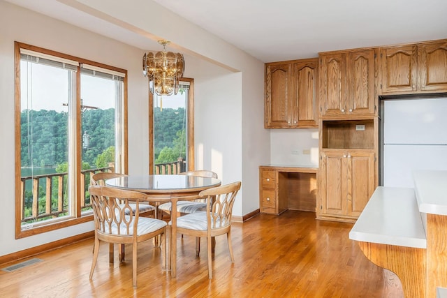 1634 Falling Water Rd, Sparta, TN 38583 - dining room featuring a chandelier, light wood finished floors, and baseboards