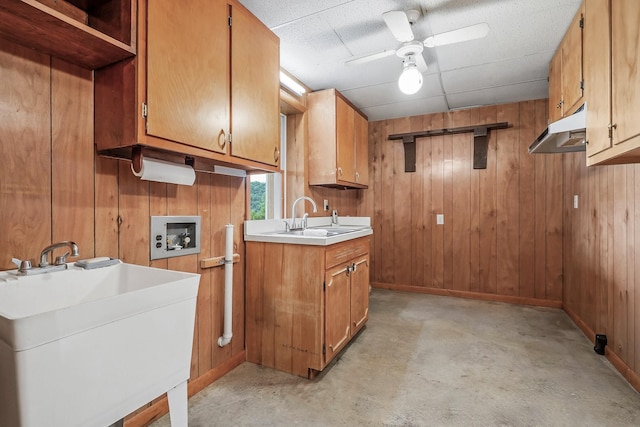 1634 Falling Water Rd, Sparta, TN 38583 - kitchen featuring a sink, concrete floors, wooden walls, brown cabinetry, and under cabinet range hood