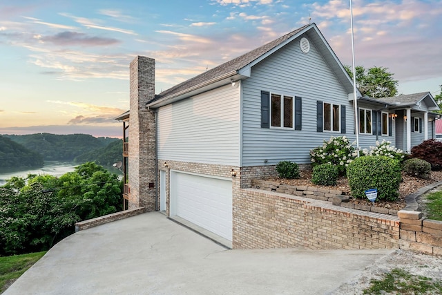 1634 Falling Water Rd, Sparta, TN 38583 - view of home's exterior with an attached garage, a chimney, and driveway