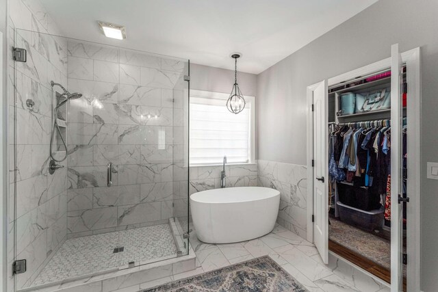 115 Wise Rd, Franklin, TN 37064 - full bathroom with a freestanding bath, marble look tile flooring, a shower stall, a spacious closet, and tile walls