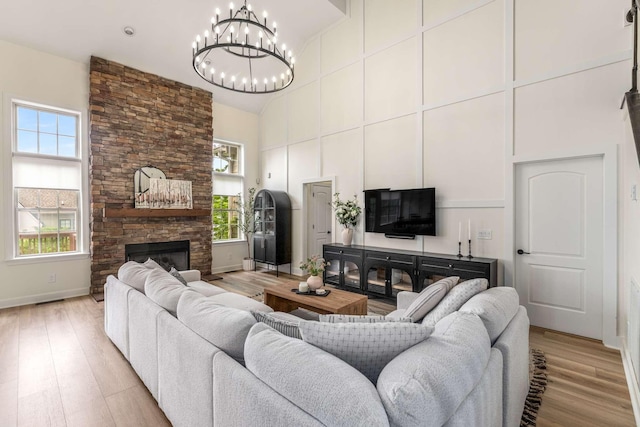 115 Wise Rd, Franklin, TN 37064 - living room with high vaulted ceiling, light wood finished floors, a chandelier, a fireplace, and baseboards