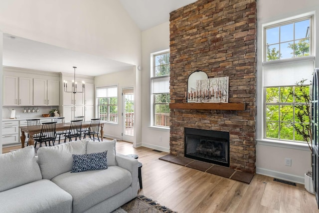 115 Wise Rd, Franklin, TN 37064 - living room with baseboards, a chandelier, light wood-style floors, a fireplace, and high vaulted ceiling