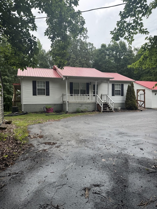 2080 Winsett Rd, Springville, TN 38256 - view of front of property featuring covered porch, driveway, metal roof, and cooling unit