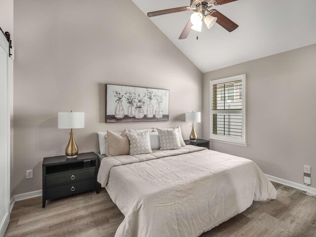3031 Joseph Dr, Spring Hill, TN 37174 - bedroom with wood finished floors, a barn door, baseboards, ceiling fan, and high vaulted ceiling