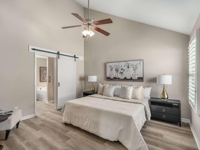 3031 Joseph Dr, Spring Hill, TN 37174 - bedroom featuring a barn door, wood finished floors, high vaulted ceiling, multiple windows, and baseboards