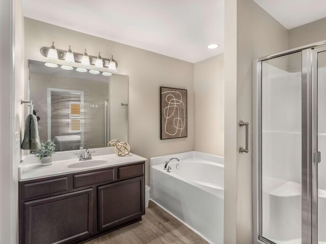 3031 Joseph Dr, Spring Hill, TN 37174 - bathroom featuring a stall shower, vanity, a garden tub, wood finished floors, and recessed lighting