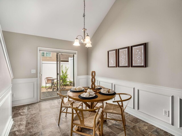 3031 Joseph Dr, Spring Hill, TN 37174 - dining space featuring wainscoting, a decorative wall, high vaulted ceiling, a chandelier, and stone finish flooring