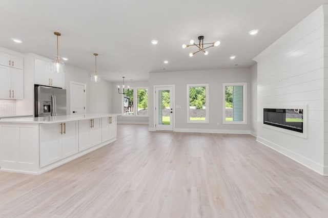 363 S Walnut Ave, Cookeville, TN 38501 - unfurnished living room featuring a chandelier, a glass covered fireplace, light wood-type flooring, recessed lighting, and baseboards