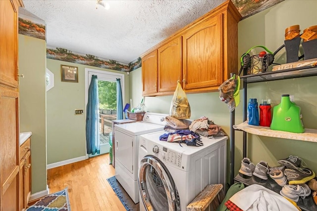 431 Jack Thomas Dr, Manchester, TN 37355 - laundry room with washing machine and clothes dryer, light wood-style floors, a textured ceiling, cabinet space, and baseboards