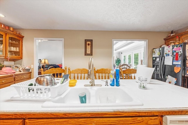 431 Jack Thomas Dr, Manchester, TN 37355 - kitchen with a sink, refrigerator with ice dispenser, brown cabinetry, tile counters, and a textured ceiling