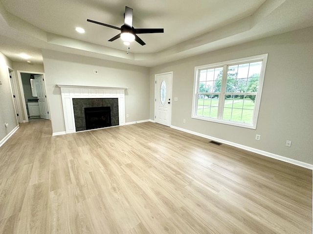 115 Briley Ln, Portland, TN 37148 - unfurnished living room featuring a tray ceiling, a ceiling fan, a tile fireplace, baseboards, and wood finished floors