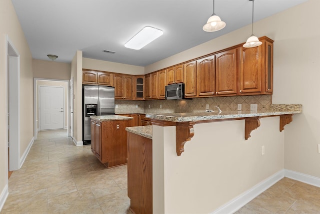 226 Wrennewood Ln, Franklin, TN 37064 - kitchen featuring stainless steel appliances, brown cabinetry, baseboards, and backsplash