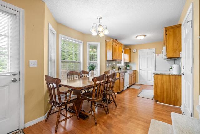 3700 Wheatfield Ln, Clarksville, TN 37040 - dining area featuring light wood-style flooring, a chandelier, a textured ceiling, and baseboards