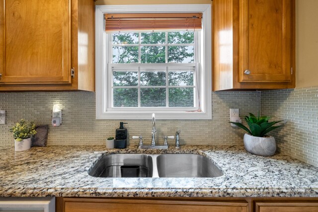 3700 Wheatfield Ln, Clarksville, TN 37040 - kitchen with a sink, tasteful backsplash, brown cabinets, and light stone countertops