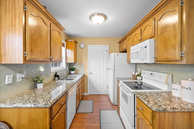 3700 Wheatfield Ln, Clarksville, TN 37040 - kitchen with white appliances, a sink, light wood-type flooring, a textured ceiling, and tasteful backsplash