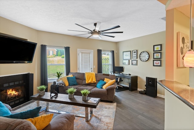 1515 Bridgecrest Dr Unit 220, Antioch, TN 37013 - living area with a ceiling fan, wood finished floors, a lit fireplace, baseboards, and a textured ceiling