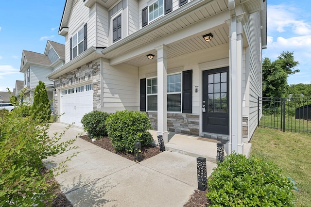 3211 Briar Chapel Dr, Murfreesboro, TN 37128 - view of exterior entry with an attached garage, stone siding, a porch, and concrete driveway