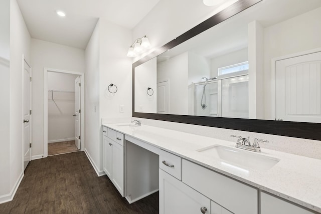 3211 Briar Chapel Dr, Murfreesboro, TN 37128 - bathroom with a stall shower, double vanity, a walk in closet, wood finished floors, and baseboards