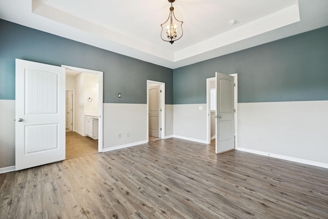 3211 Briar Chapel Dr, Murfreesboro, TN 37128 - spare room featuring a raised ceiling, wood finished floors, crown molding, a chandelier, and baseboards