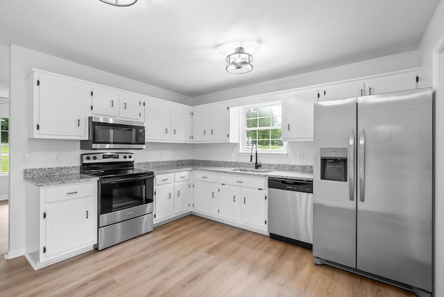 171 Stephanie Dr, Clarksville, TN 37042 - kitchen featuring appliances with stainless steel finishes, a sink, white cabinetry, and light wood-style flooring