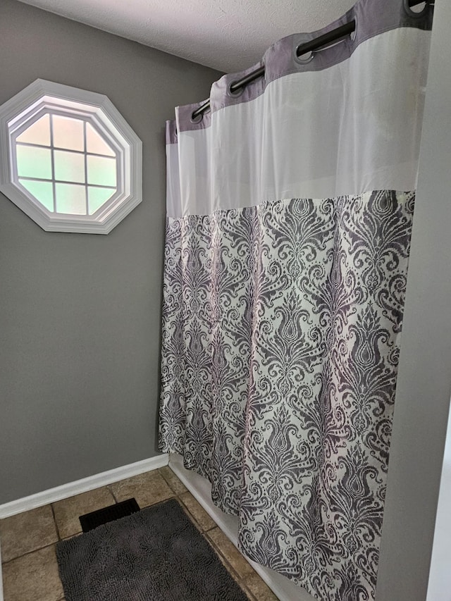 2524 Distillery Rd, Greenbrier, TN 37073 - full bath with a shower with shower curtain, tile patterned flooring, baseboards, and a textured ceiling