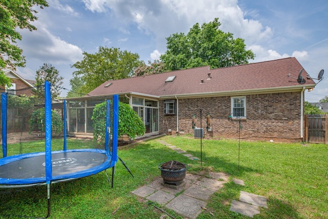 314 Millhouse Rd, Smyrna, TN 37167 - rear view of property with a trampoline, a fire pit, brick siding, and a sunroom