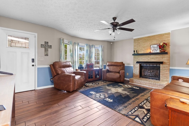 314 Millhouse Rd, Smyrna, TN 37167 - living room featuring wood finished floors, ceiling fan, a brick fireplace, a textured ceiling, and baseboards