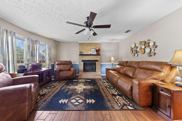 314 Millhouse Rd, Smyrna, TN 37167 - living room with hardwood / wood-style flooring, a ceiling fan, a textured ceiling, and a brick fireplace