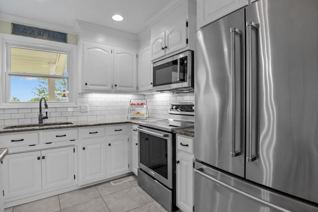 346 Spring Creek Ln, Lebanon, TN 37090 - kitchen featuring stainless steel appliances, a sink, dark stone countertops, white cabinetry, and light tile patterned flooring