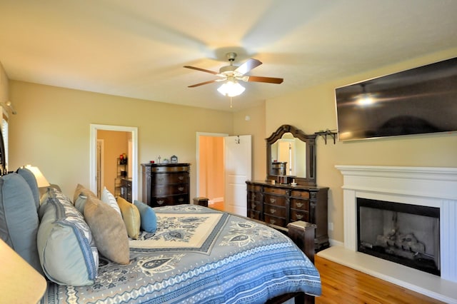 3173 Porter Hills Dr, Clarksville, TN 37043 - bedroom with wood finished floors, a fireplace with raised hearth, a ceiling fan, and baseboards