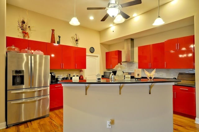 3173 Porter Hills Dr, Clarksville, TN 37043 - kitchen featuring appliances with stainless steel finishes, red cabinets, wall chimney range hood, dark countertops, and light wood-style flooring