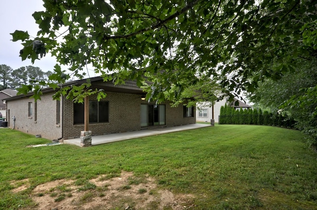 3173 Porter Hills Dr, Clarksville, TN 37043 - rear view of house with brick siding, a patio, and a lawn