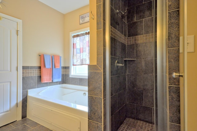 3173 Porter Hills Dr, Clarksville, TN 37043 - bathroom featuring a shower stall, a jetted tub, tile walls, tile patterned floors, and wainscoting