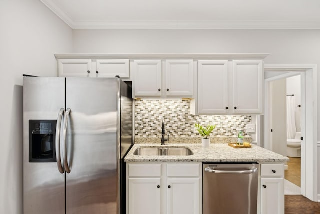 1101 Downs Blvd Unit 295, Franklin, TN 37064 - kitchen featuring appliances with stainless steel finishes, a sink, crown molding, decorative backsplash, and white cabinets