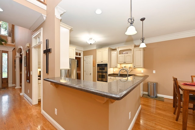 1043 Dorset Dr, Hendersonville, TN 37075 - kitchen with a peninsula, stainless steel double oven, a kitchen breakfast bar, a sink, and ornamental molding