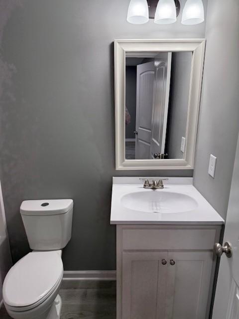 406 New Rock Creek Rd, Tullahoma, TN 37388 - bathroom featuring vanity, toilet, baseboards, and wood finished floors