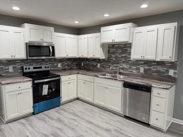 406 New Rock Creek Rd, Tullahoma, TN 37388 - kitchen featuring appliances with stainless steel finishes, a sink, light wood-style floors, white cabinets, and recessed lighting
