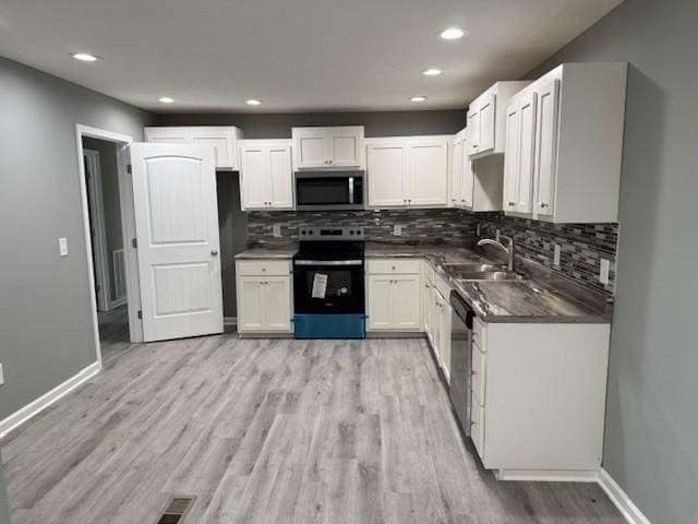 406 New Rock Creek Rd, Tullahoma, TN 37388 - kitchen featuring stainless steel appliances, a sink, dark countertops, light wood finished floors, and backsplash