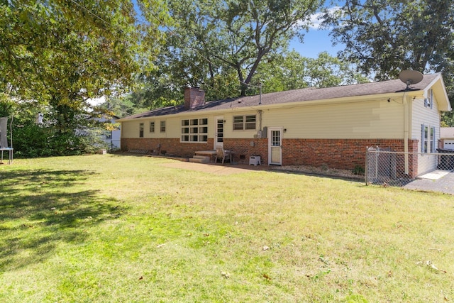 608 Bragg Cir, Tullahoma, TN 37388 - back of house featuring a trampoline, brick siding, a chimney, and entry steps