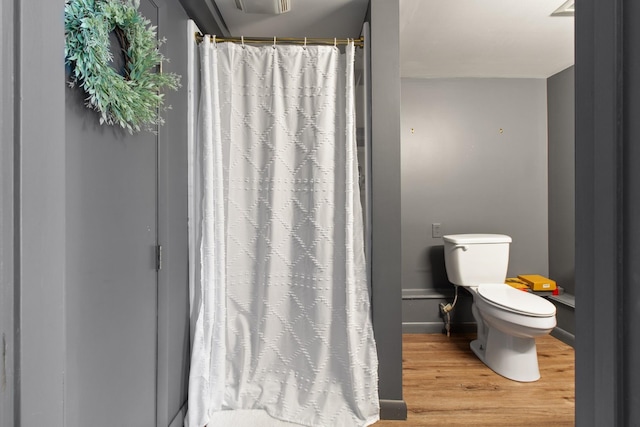 608 Bragg Cir, Tullahoma, TN 37388 - bathroom with toilet, wood finished floors, a shower with shower curtain, and baseboards