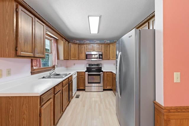 366 Huffman Park Rd, Lynchburg, TN 37352 - kitchen featuring appliances with stainless steel finishes, a sink, brown cabinets, and light wood-style floors