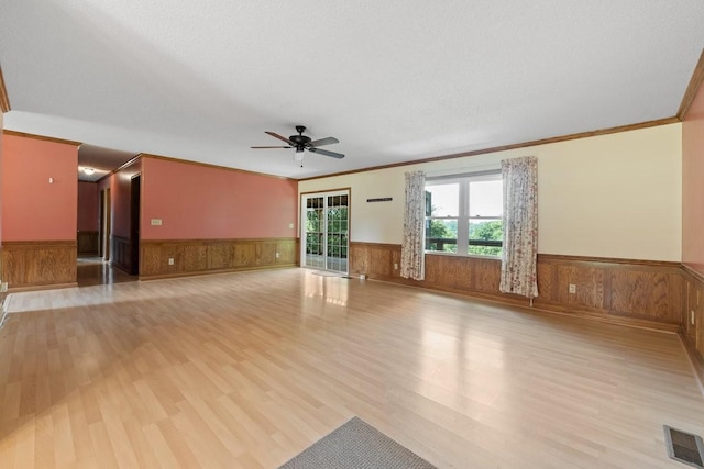 366 Huffman Park Rd, Lynchburg, TN 37352 - unfurnished living room featuring wainscoting, light wood-style flooring, ceiling fan, and ornamental molding