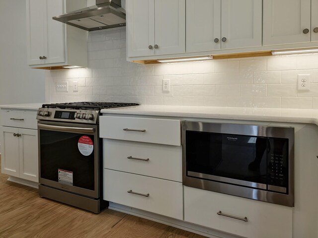 7115 Frances St, Fairview, TN 37062 - kitchen with gas range, wall chimney range hood, black microwave, light countertops, and backsplash