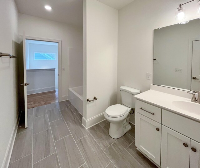 7115 Frances St, Fairview, TN 37062 - bathroom with toilet, vanity, a tub, wood tiled floors, and recessed lighting