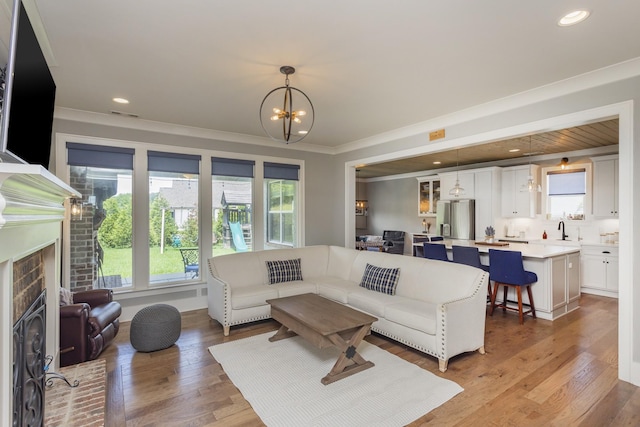 6575 Windmill Dr, College Grove, TN 37046 - living area with a chandelier, ornamental molding, a fireplace, light wood-style floors, and recessed lighting