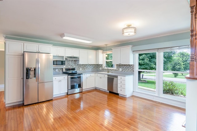 930 Rossview Rd, Clarksville, TN 37043 - kitchen with appliances with stainless steel finishes, light wood-style floors, backsplash, white cabinetry, and ornamental molding