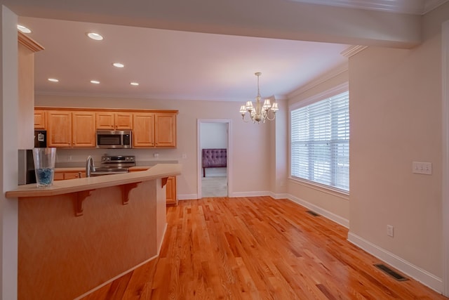 107 Hunters Ct, Tullahoma, TN 37388 - kitchen with stainless steel appliances, a kitchen bar, light countertops, a chandelier, and crown molding