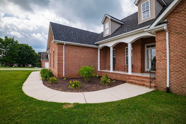107 Hunters Ct, Tullahoma, TN 37388 - view of home's exterior with brick siding, covered porch, a yard, and roof with shingles