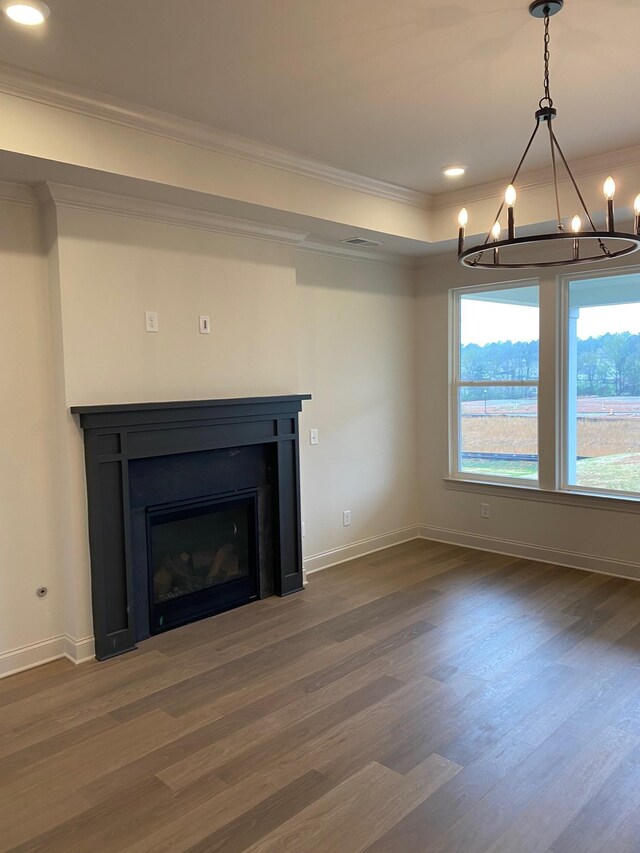 7317 Katherine Ct, Fairview, TN 37062 - unfurnished living room with a chandelier, crown molding, dark wood-style floors, a glass covered fireplace, and baseboards